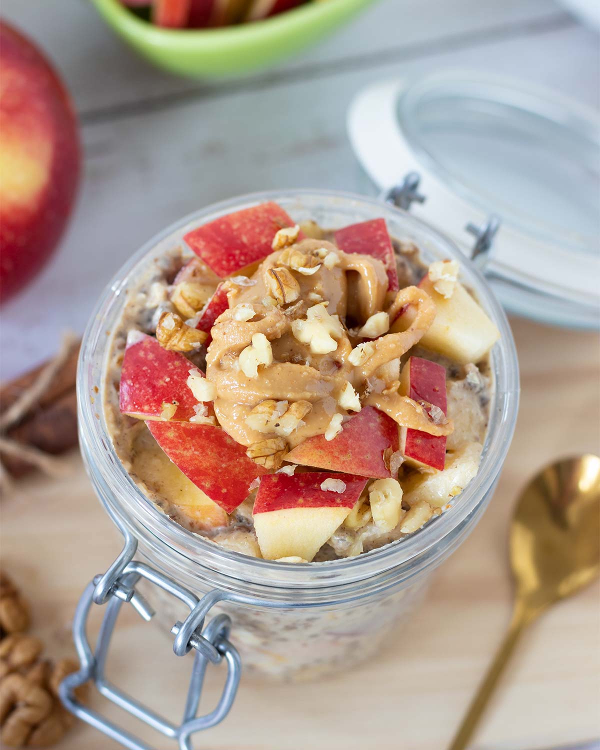 Protein cinnamon apple overnight oats in a jar with peanut butter, chia seeds, and other healthy ingredients for simple fall breakfast