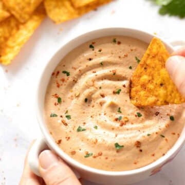 Creamy homemade vegan queso dip in a bowl with corn chips