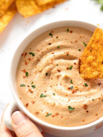 Creamy homemade vegan queso dip in a bowl with corn chips