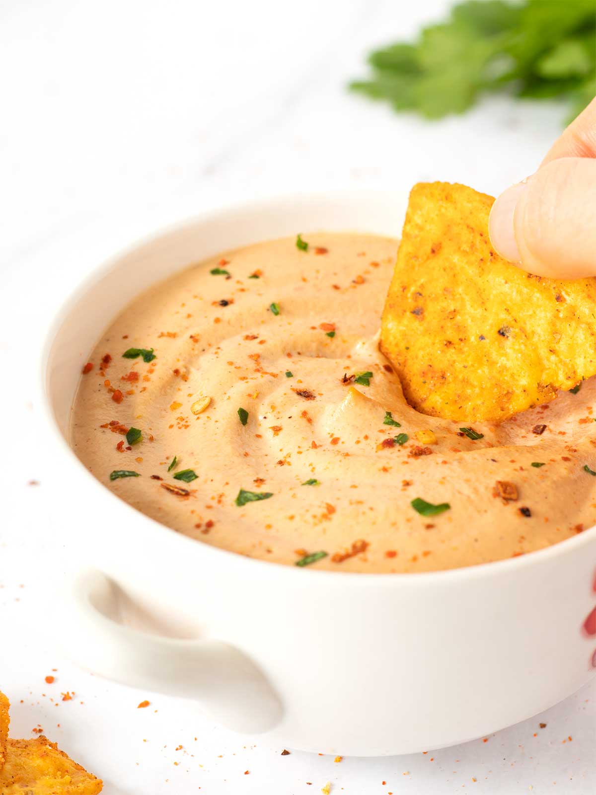 Spicy and dairy-free vegan dip in a bowl with corn chips