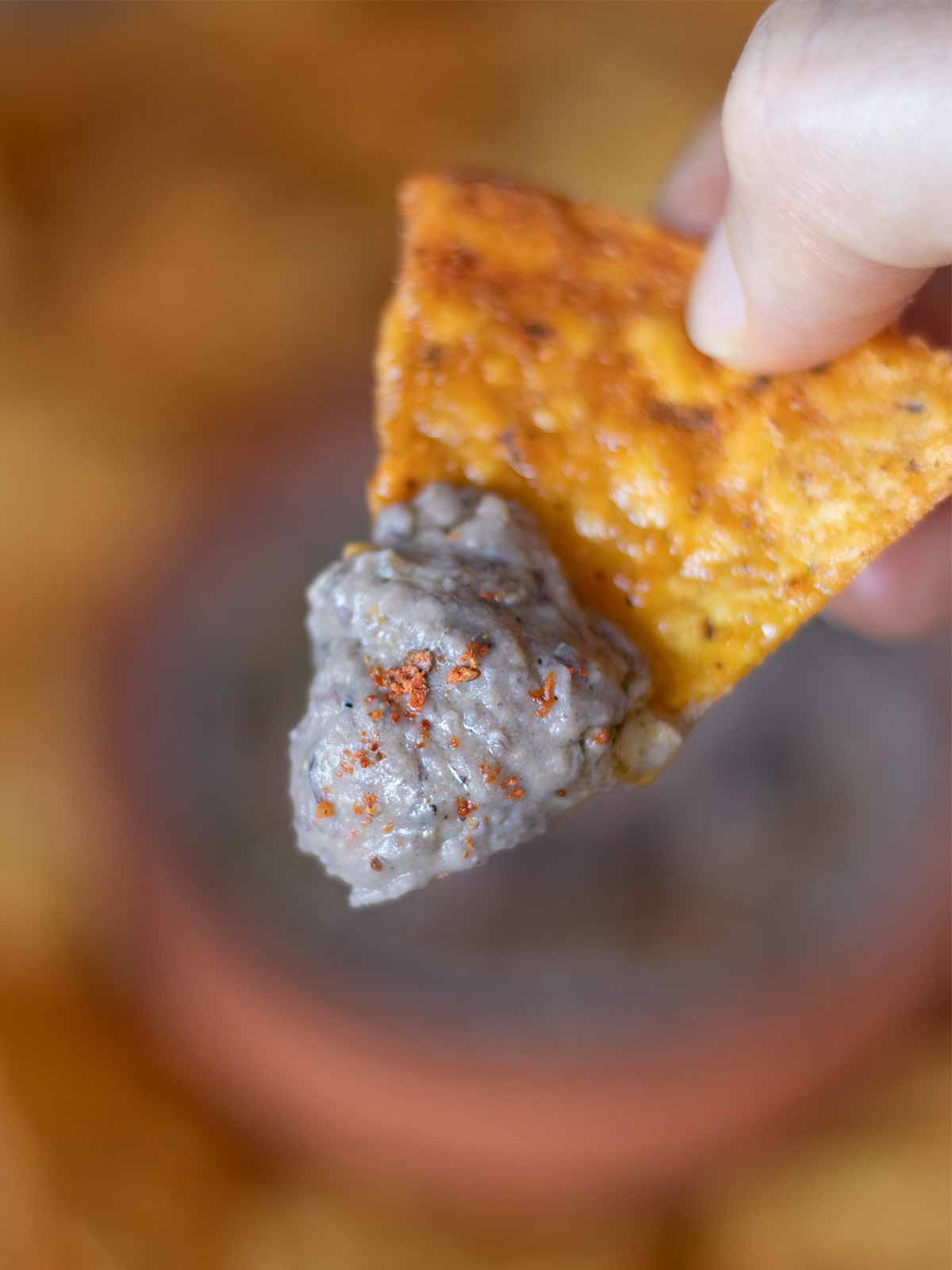 Healthy vegan bean dip on corn chips as an easy snack or appetizer