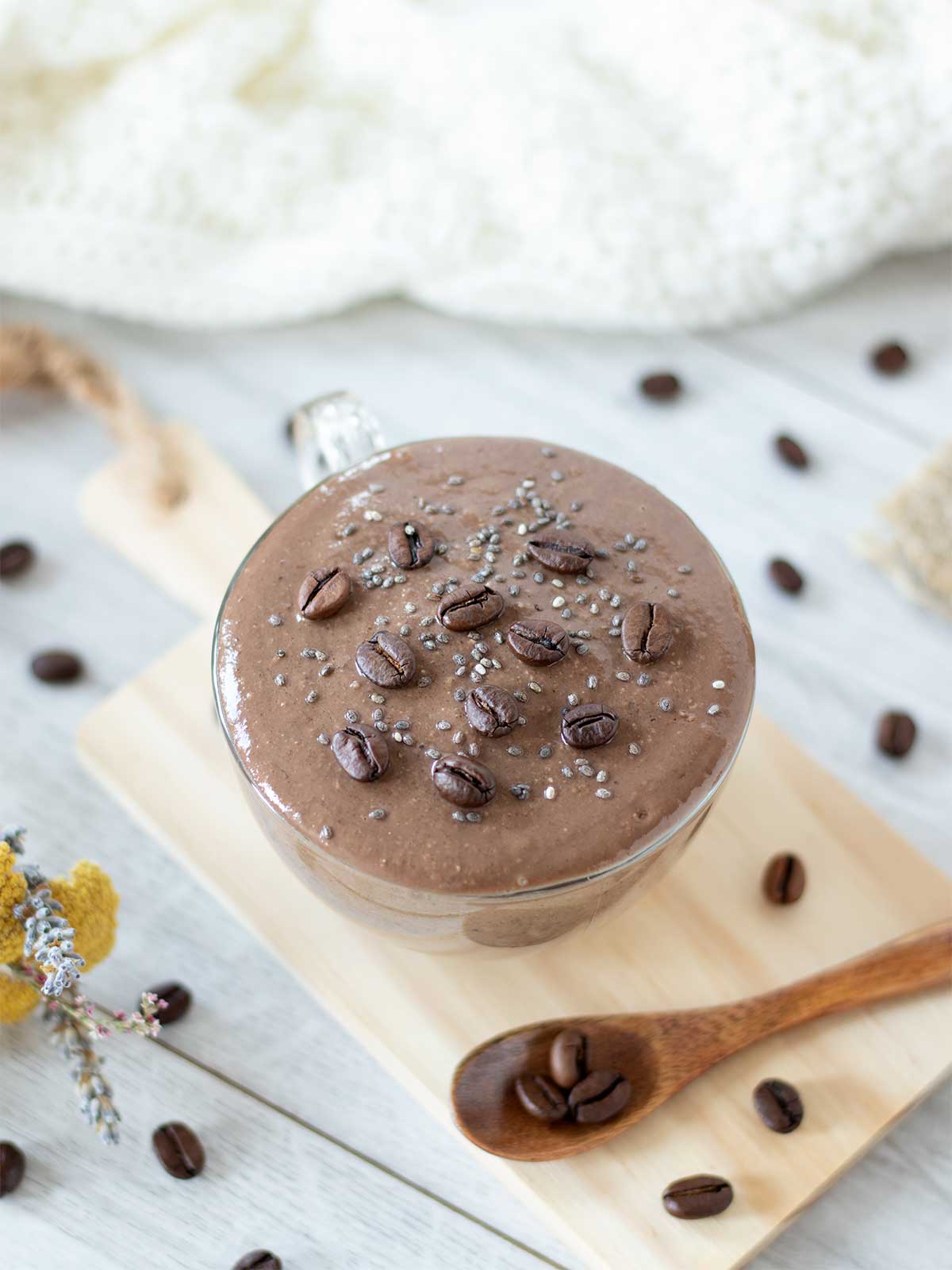 Chocolate banana coffee smoothie with oats in a cup with wooden spoon