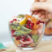 Fresh winter fruit salad with homemade poppy seed dressing in a glass cup with wooden spoon