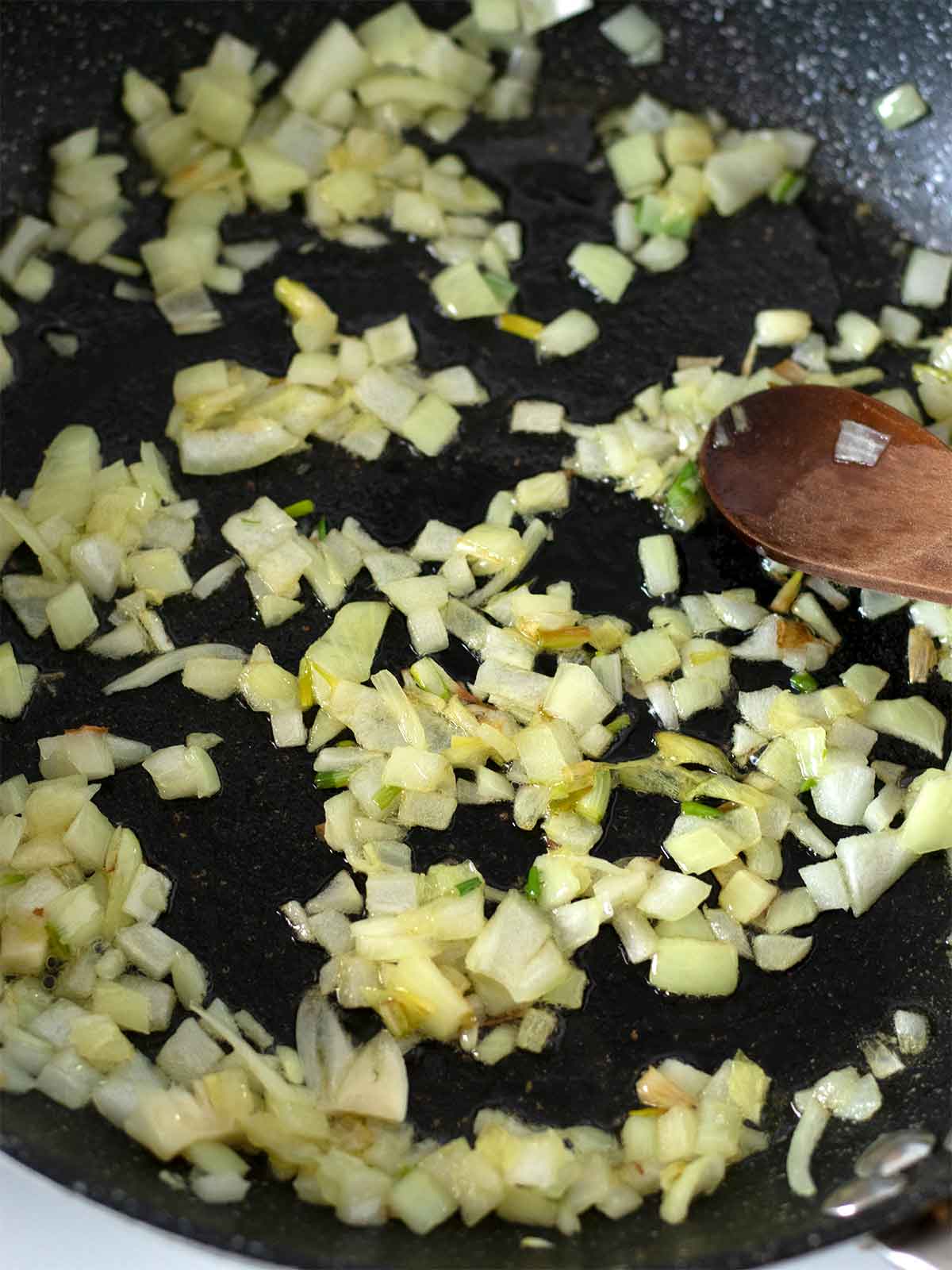 Frying chopped onion and garlic in a pan