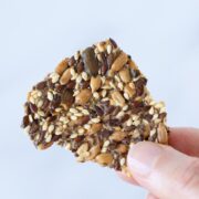 Multi seed cracker in female hand with white background