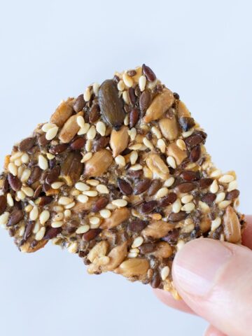 Multi seed cracker in female hand with white background