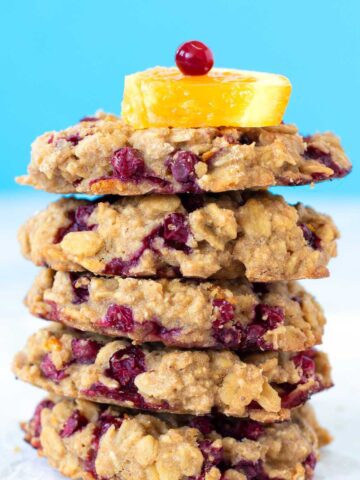 A stack of healthy gluten-free cranberry orange oatmeal cookies (vegan) with blue background