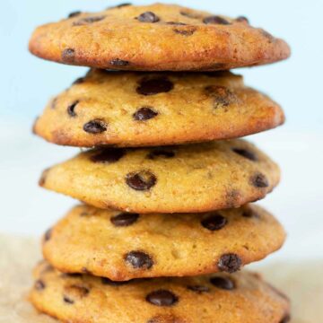 A stack of vegan chickpea flour chocolate chip cookies on parchment paper