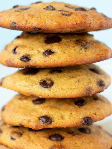A stack of vegan chickpea flour chocolate chip cookies on parchment paper