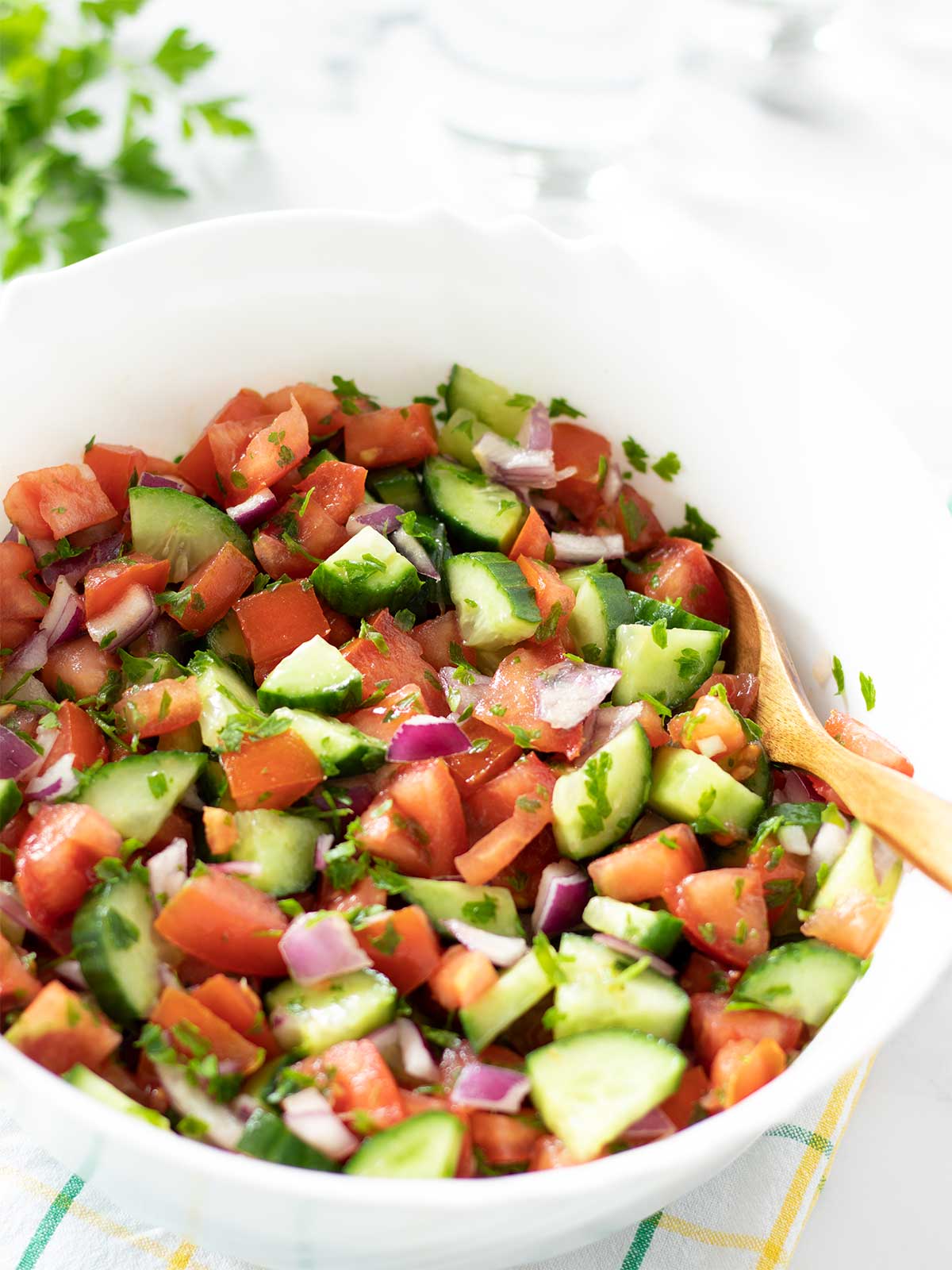 Low-calorie Mediterranean summer salad with cucumbers, tomatoes, red onion, and fresh parsley.