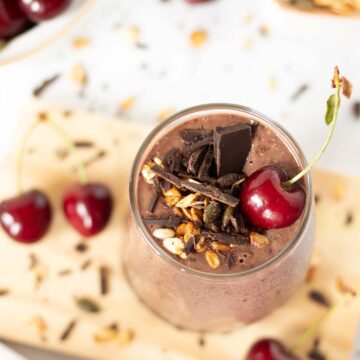 Chocolate cherry oat smoothie without banana topped with granola and chopped dark chocolate