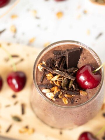 Chocolate cherry oat smoothie without banana topped with granola and chopped dark chocolate