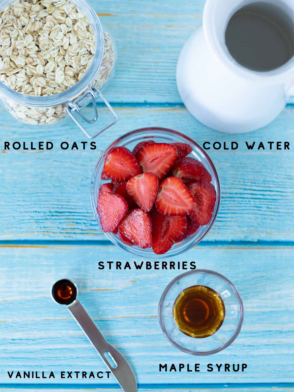 Simple plant-based ingredients for making pink nut milk at home: fresh strawberries, rolled oats, pure maple syrup, vanilla extract, and cold water.