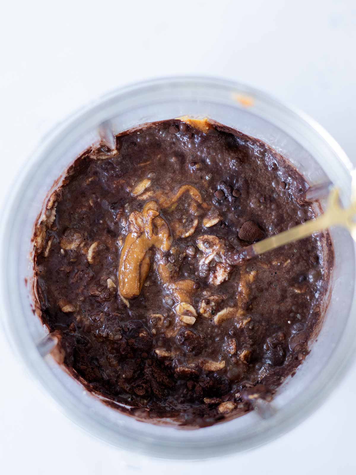 Healthy ingredients in a blender cup for vegan chocolate overnight oats meal prep