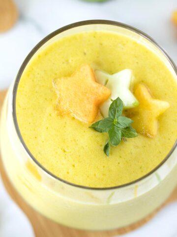 Pineapple cucumber ginger detox smoothie for weight loss topped with fresh mint.