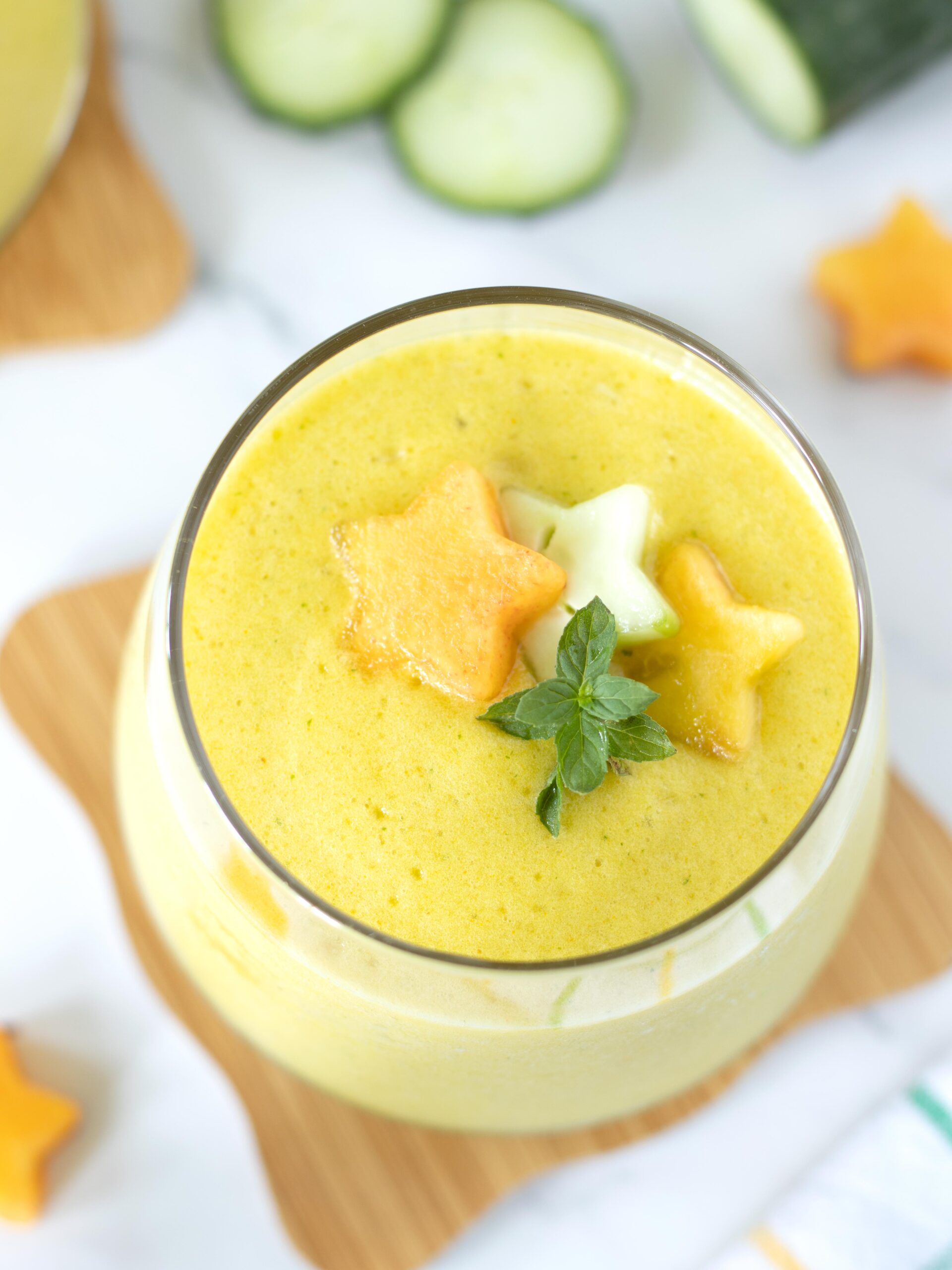 Pineapple cucumber ginger detox smoothie for weight loss topped with fresh mint.