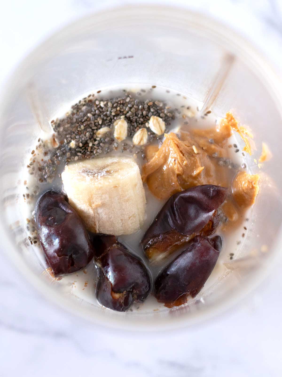 Lactose free date and banana smoothie ingredients in blender cup.