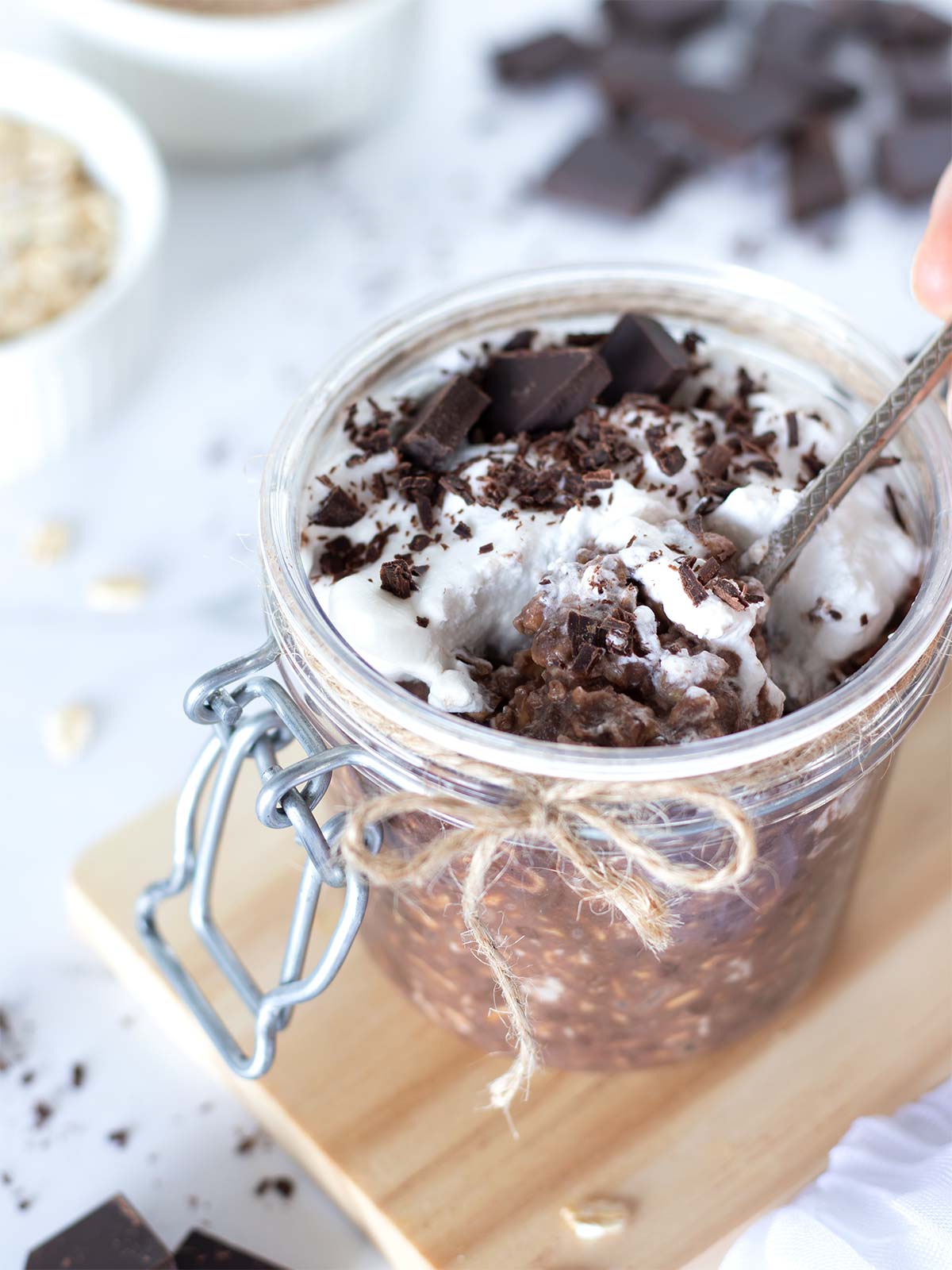 Protein packed overnight oats with chocolate flavor topped with whipped cream.