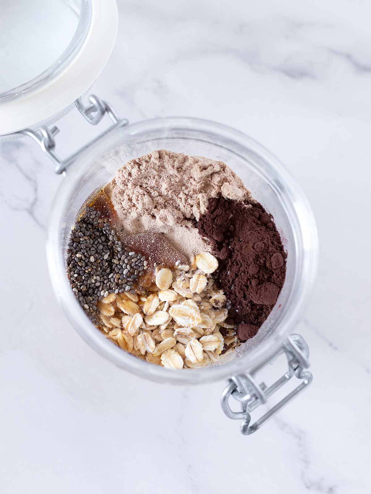 Simple ingredients for high protein proats (overnight oats) in a small jar.