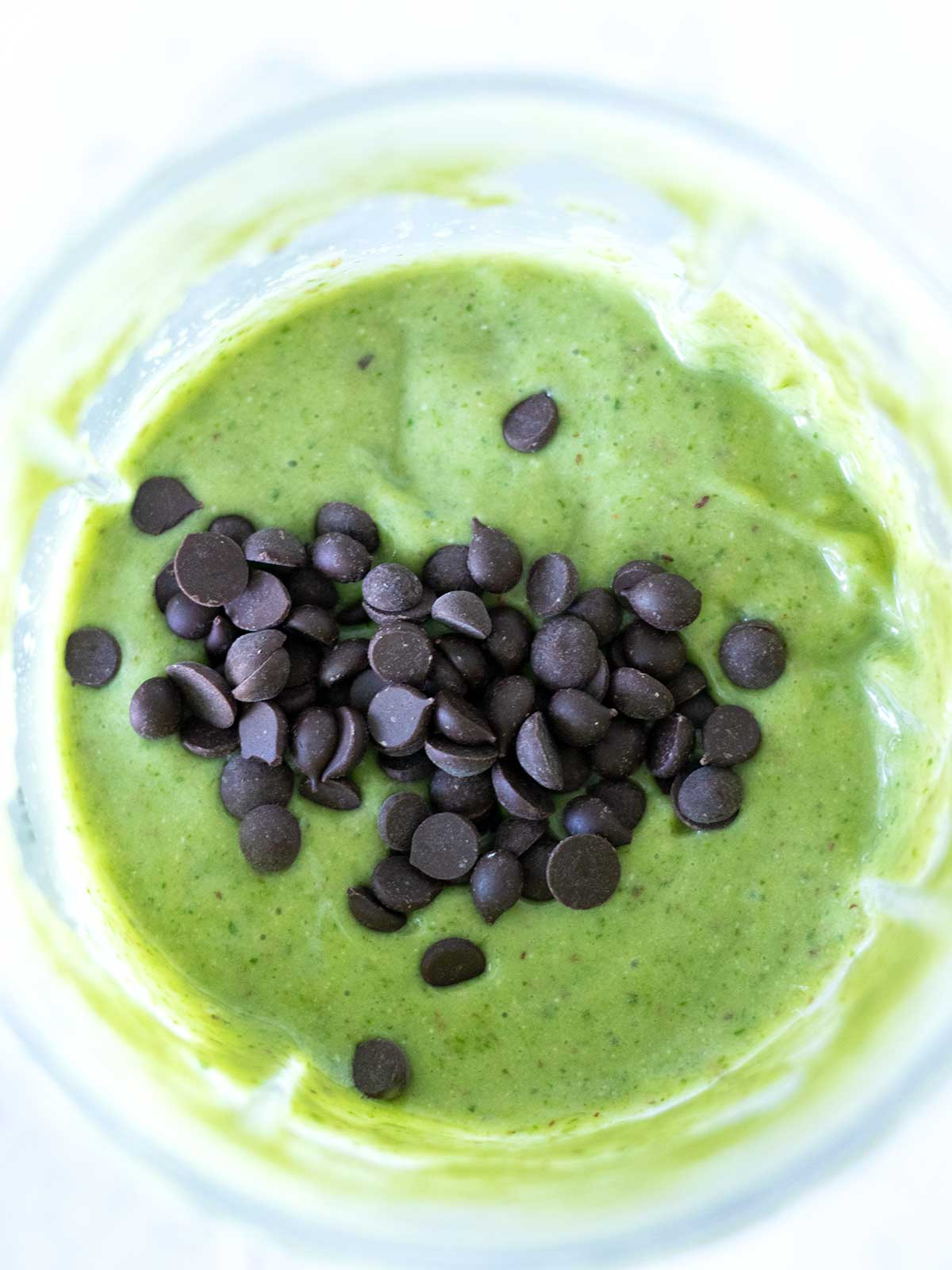 Green mint shake topped with vegan dairy-free chocolate chips.