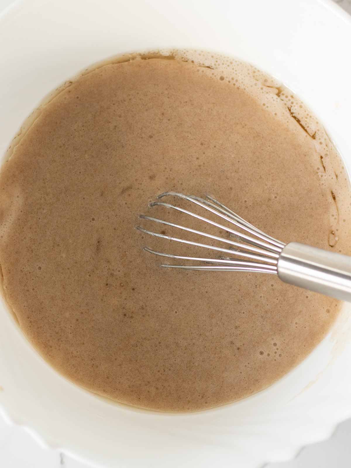 Wet ingredients for banana bread muffins in one bowl.