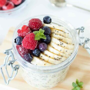 Healthy overnight oats for weight loss with frozen fruit and sliced banana.