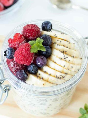 Healthy overnight oats for weight loss with frozen fruit and sliced banana.