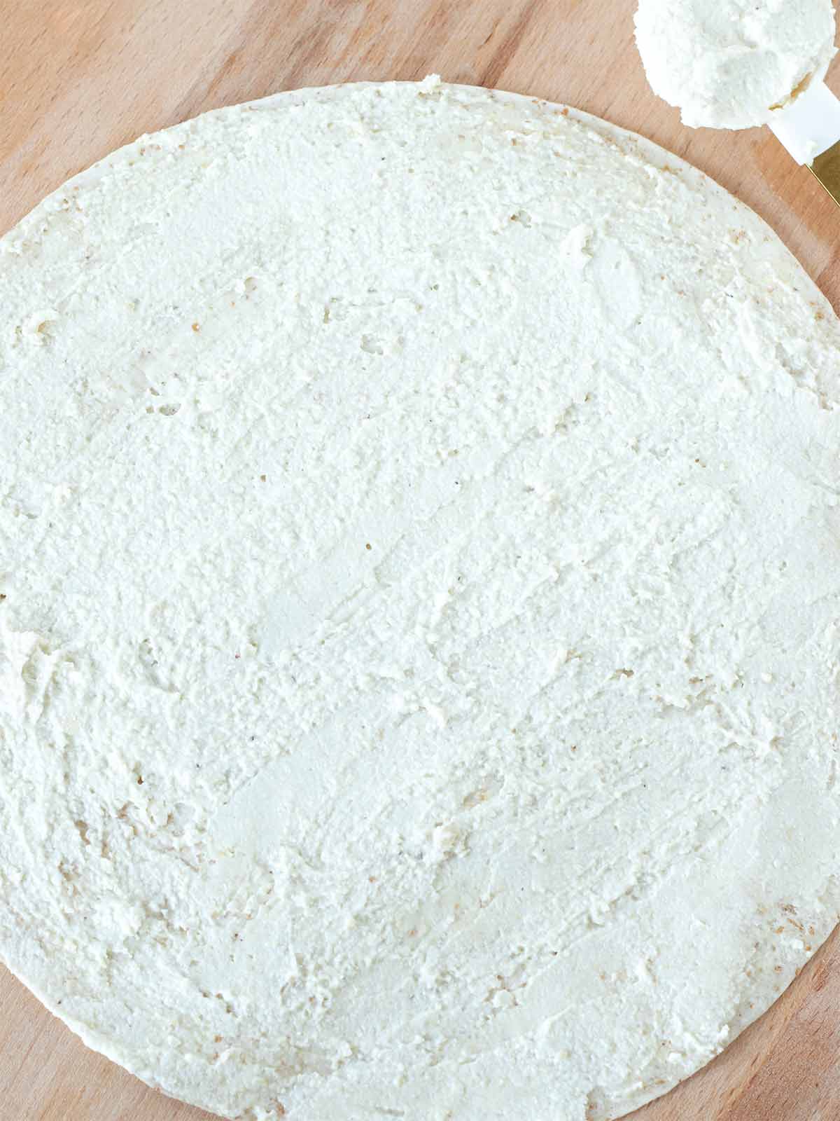 Whole wheat flour tortilla with dairy-free cream cheese spread.