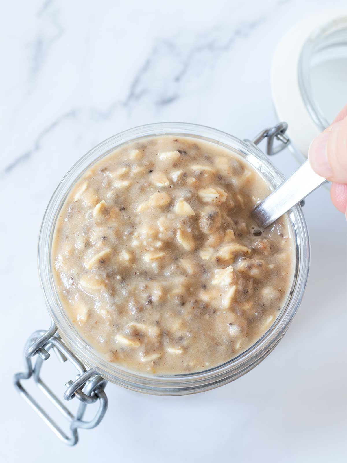 Creamy overnight oats with applesauce, cinnamon, and peanut butter for healthy vegan meal prep.