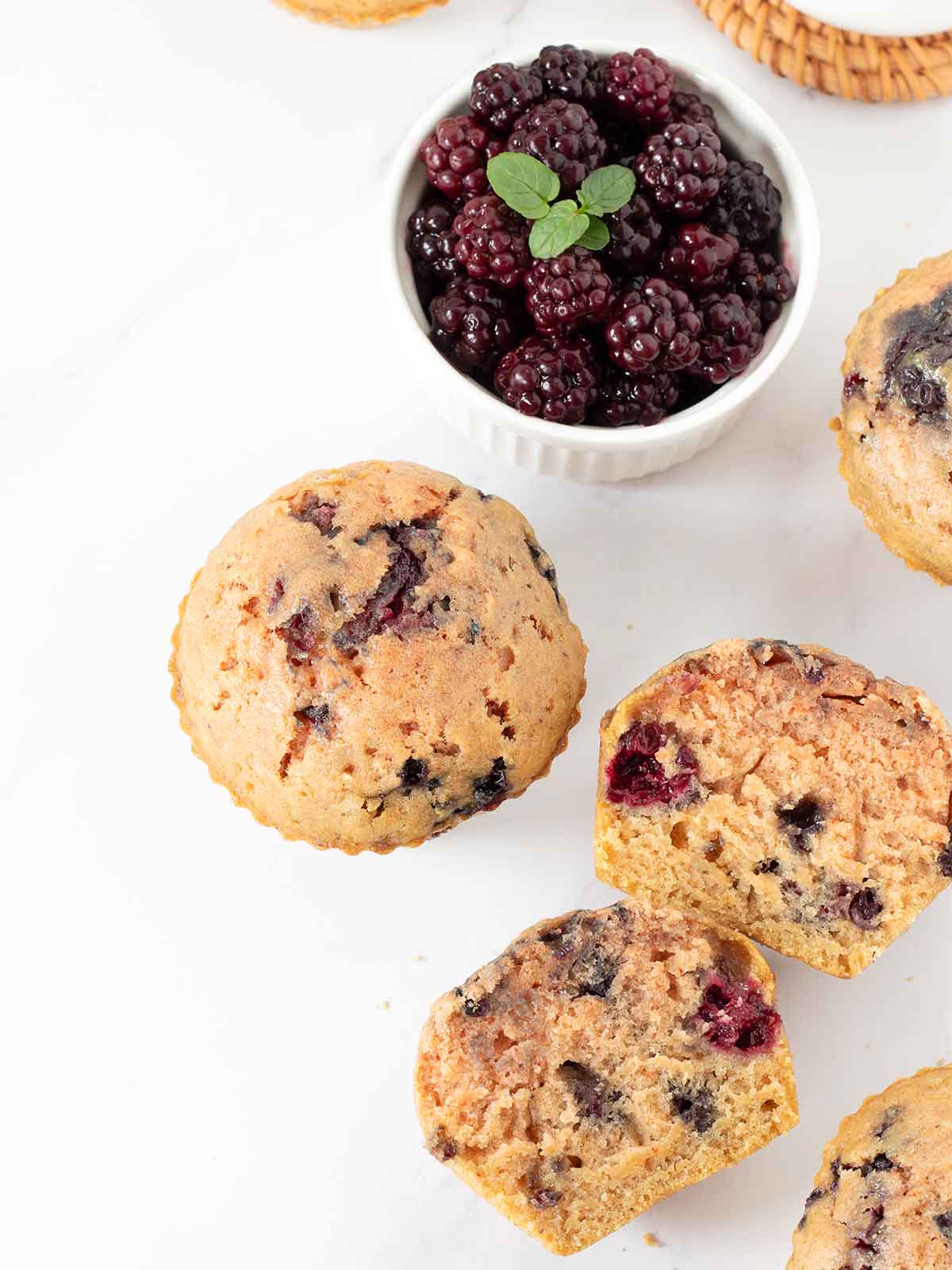 Dairy-free blackberry muffins on white table.