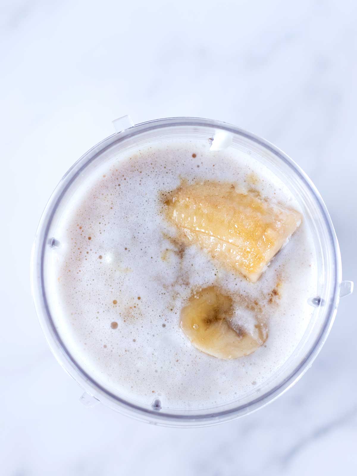 Vegan ingredients for homemade healthy coconut shake in blender cup.