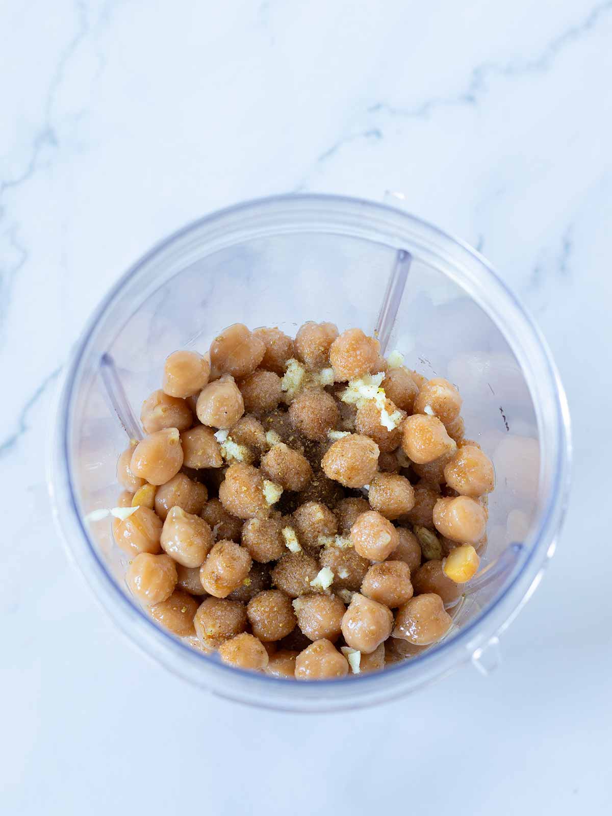 Simple ingredients for chickpea hummus without tahini in a blender cup.