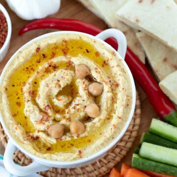 Homemade garlic hummus without tahini with fresh vegetables and pita bread.