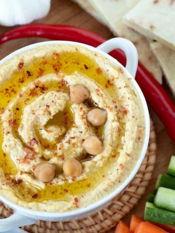 Homemade garlic hummus without tahini with fresh vegetables and pita bread.