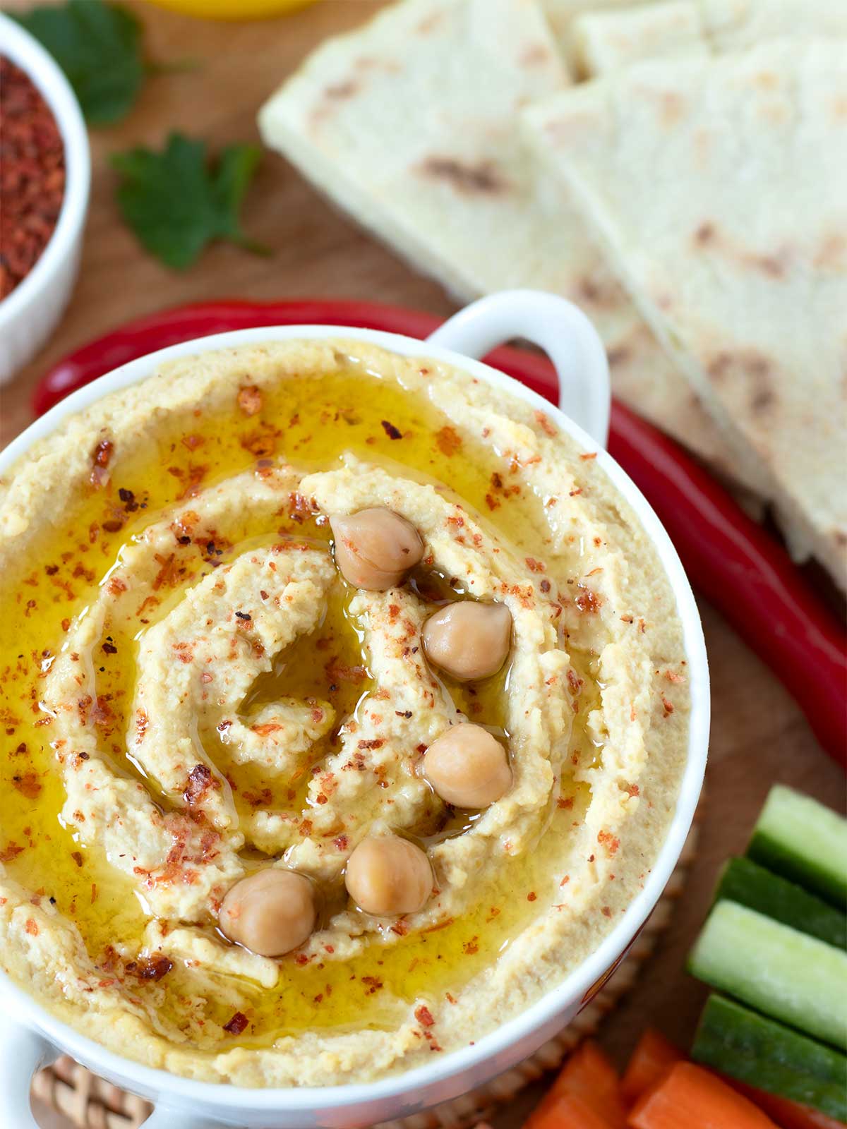 Simple homemade hummus without tahini with pita bread and fresh veggies.