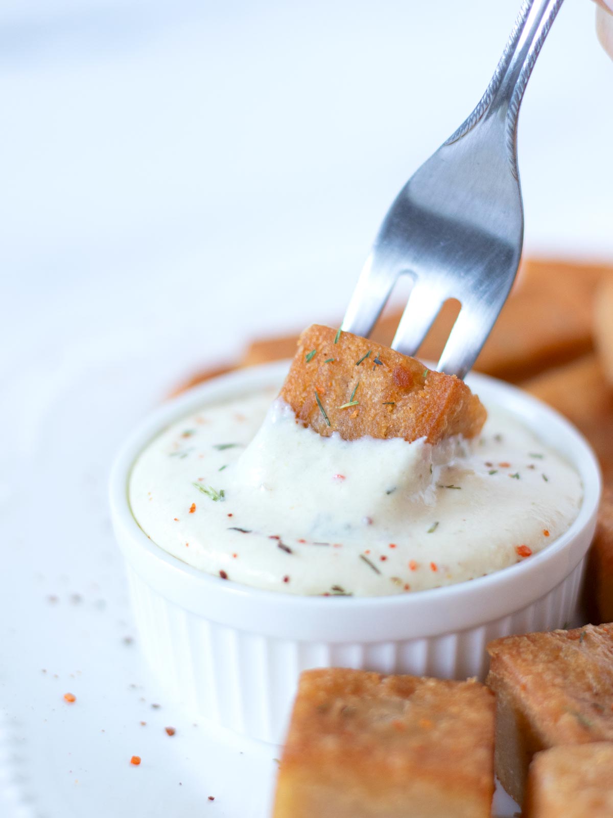 High-protein, plant-based red lentil tofu dipped in a vegan sauce.