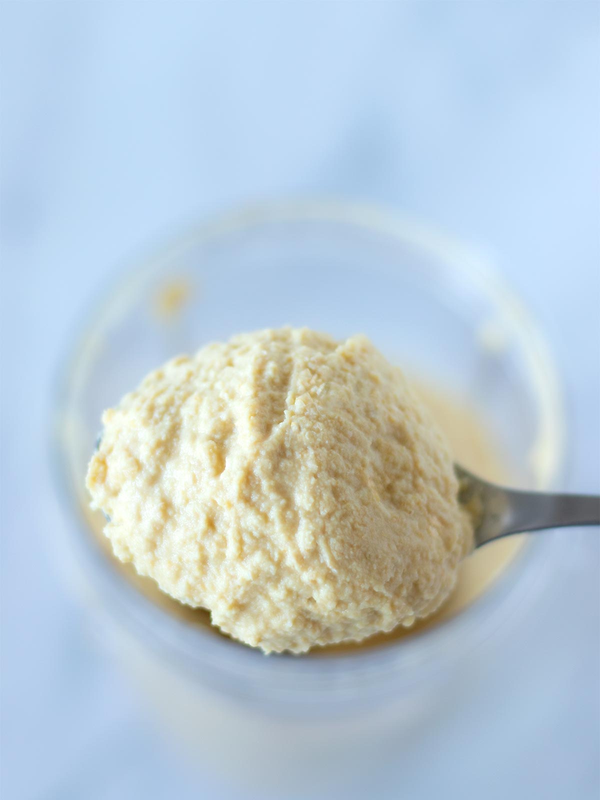 Spoonful of vegan homemade tahini-free garlic hummus.