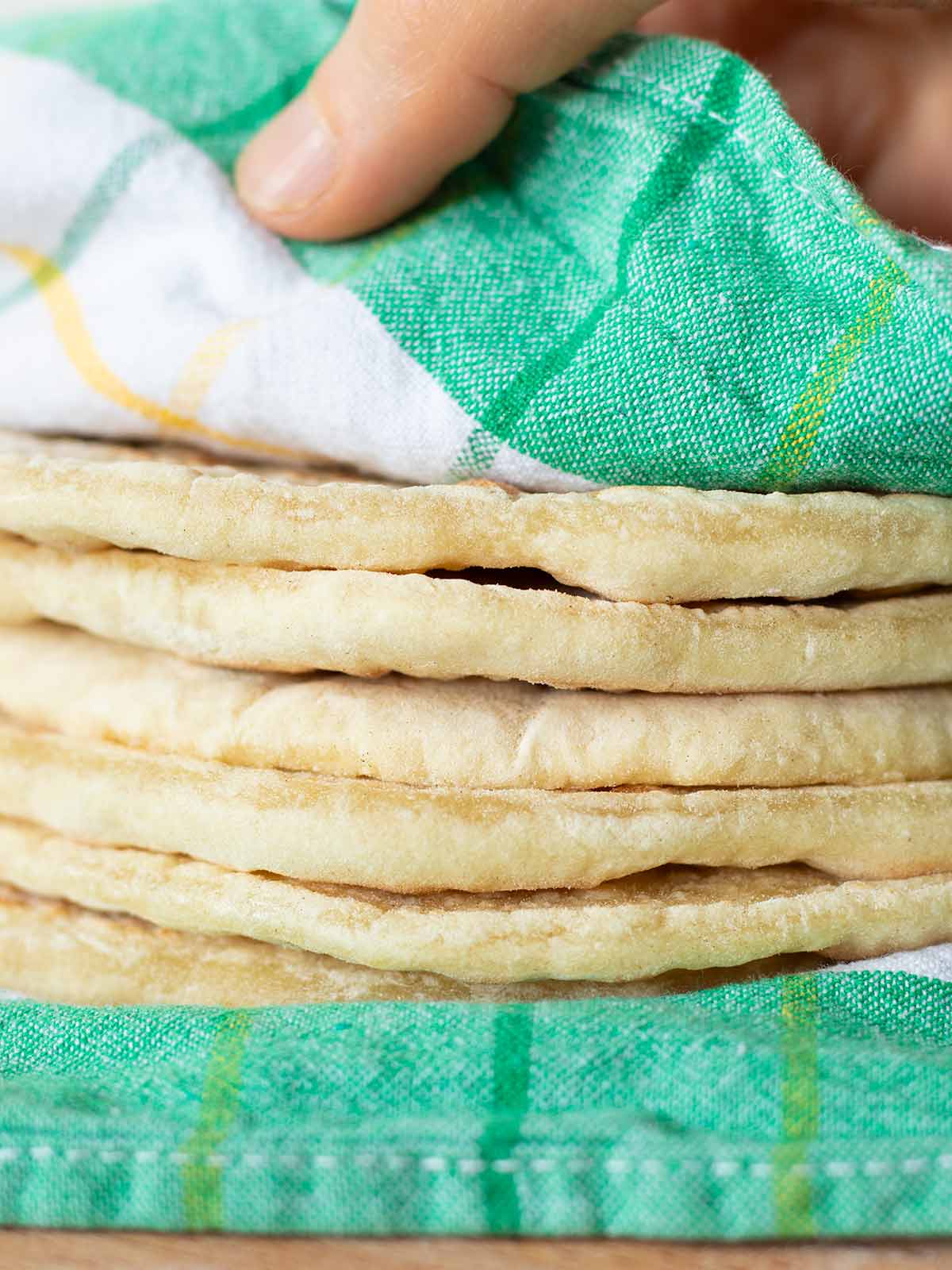 Stack of soft homemade Passover breads wrapped in clean kitchen towel.