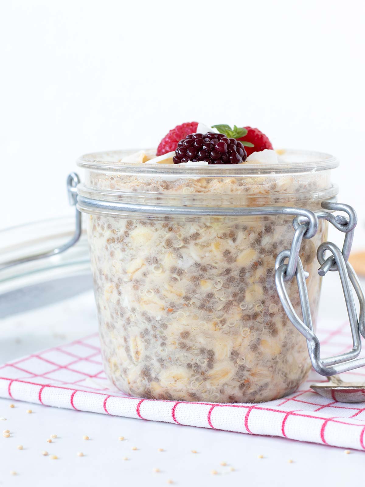 Healthy no-cook quinoa overnight oats with peanut butter, chia seeds, and fresh fruit topping.