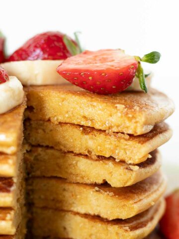 Vegan chickpea flour pancakes with strawberry, banana, and maple syrup topping.