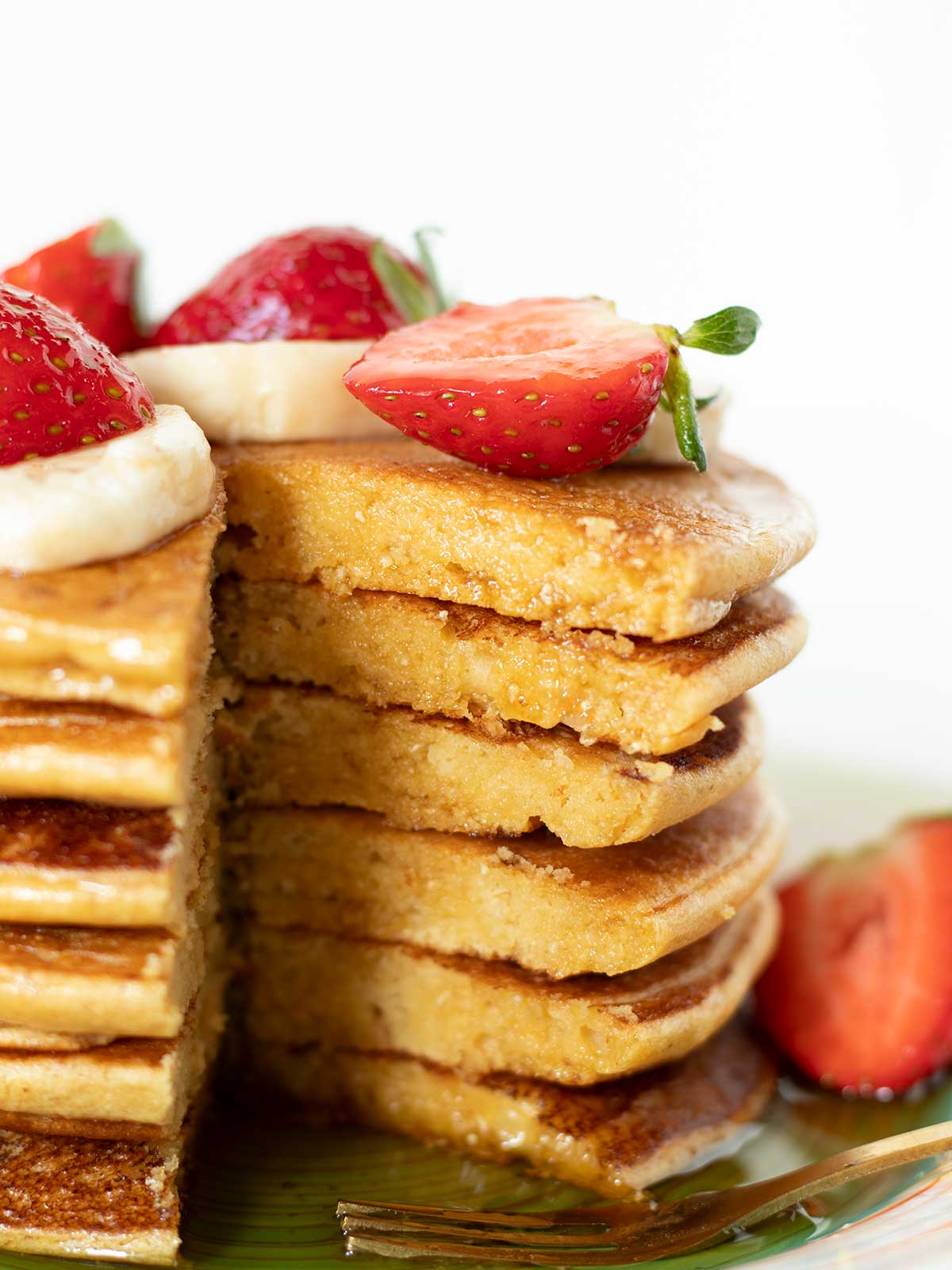 Vegan chickpea flour pancakes with strawberry, banana, and maple syrup topping.