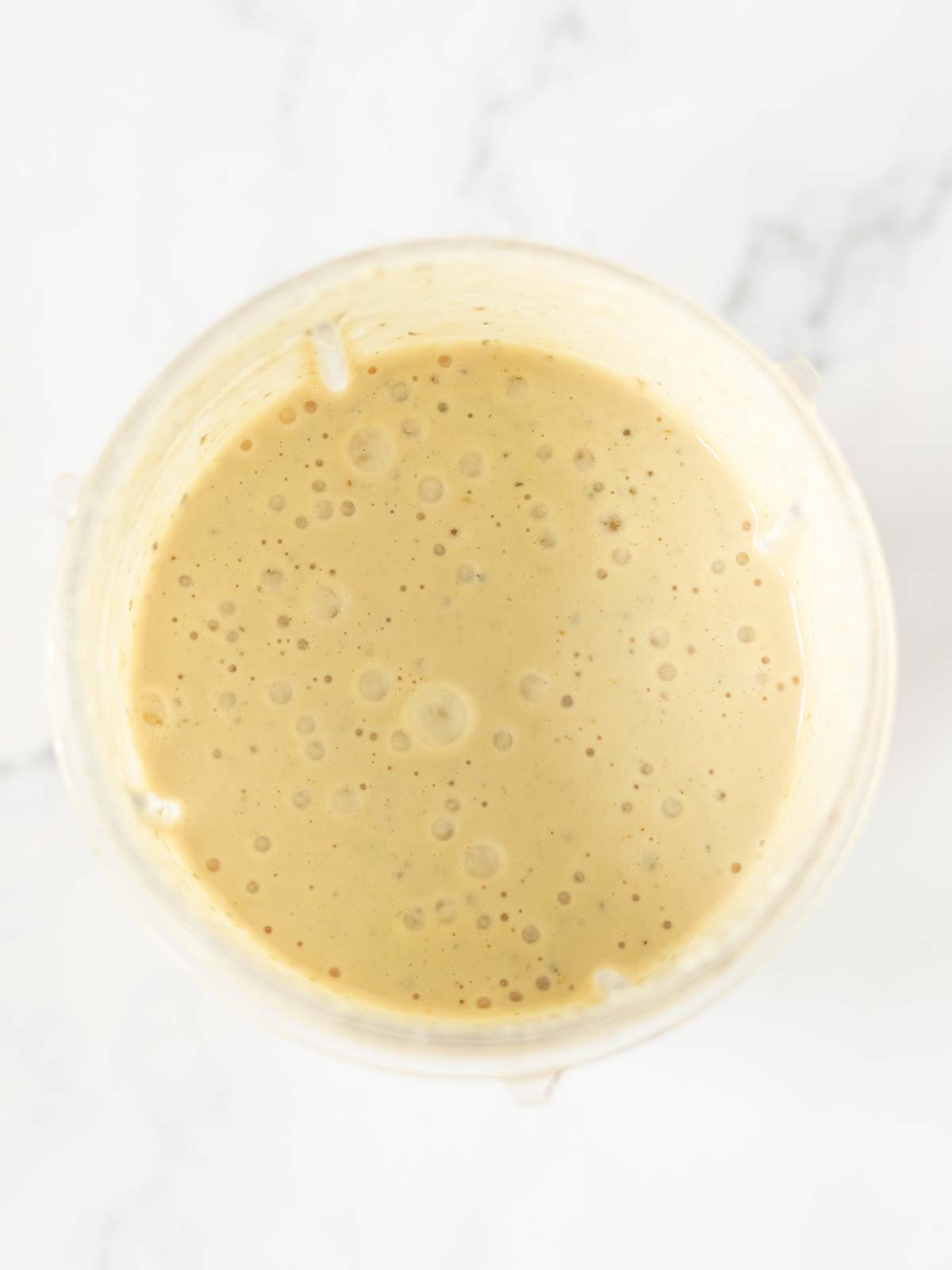 Creamy nutritional yeast dressing in blender cup.