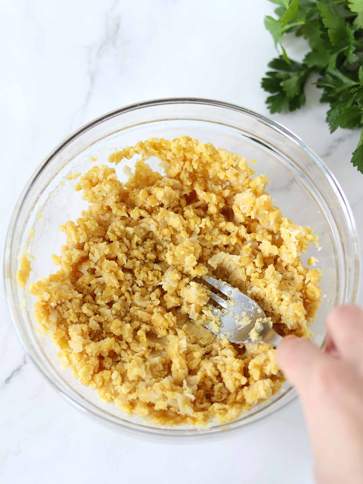 Mashed chickpeas in a bowl for healthy vegetable fritters meal prep.