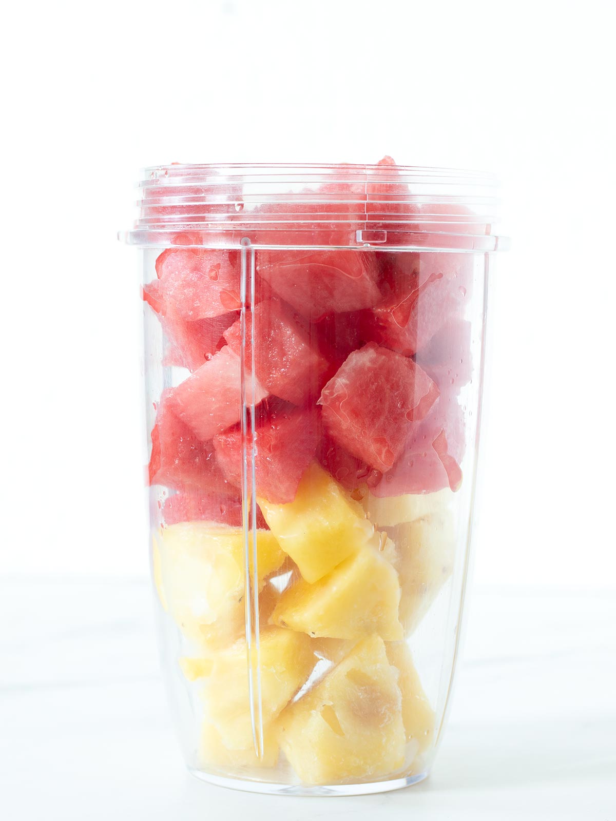 Fresh watermelon cubes and frozen pineapple chunks for healthy 2 ingredient summer fruit smoothie.