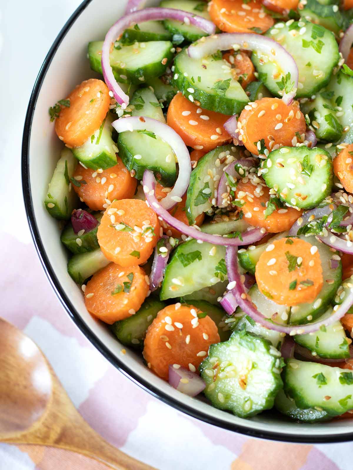 Cucumber and carrot salad with onion and parsley coated with sesame olive oil apple cider vinegar dressing.