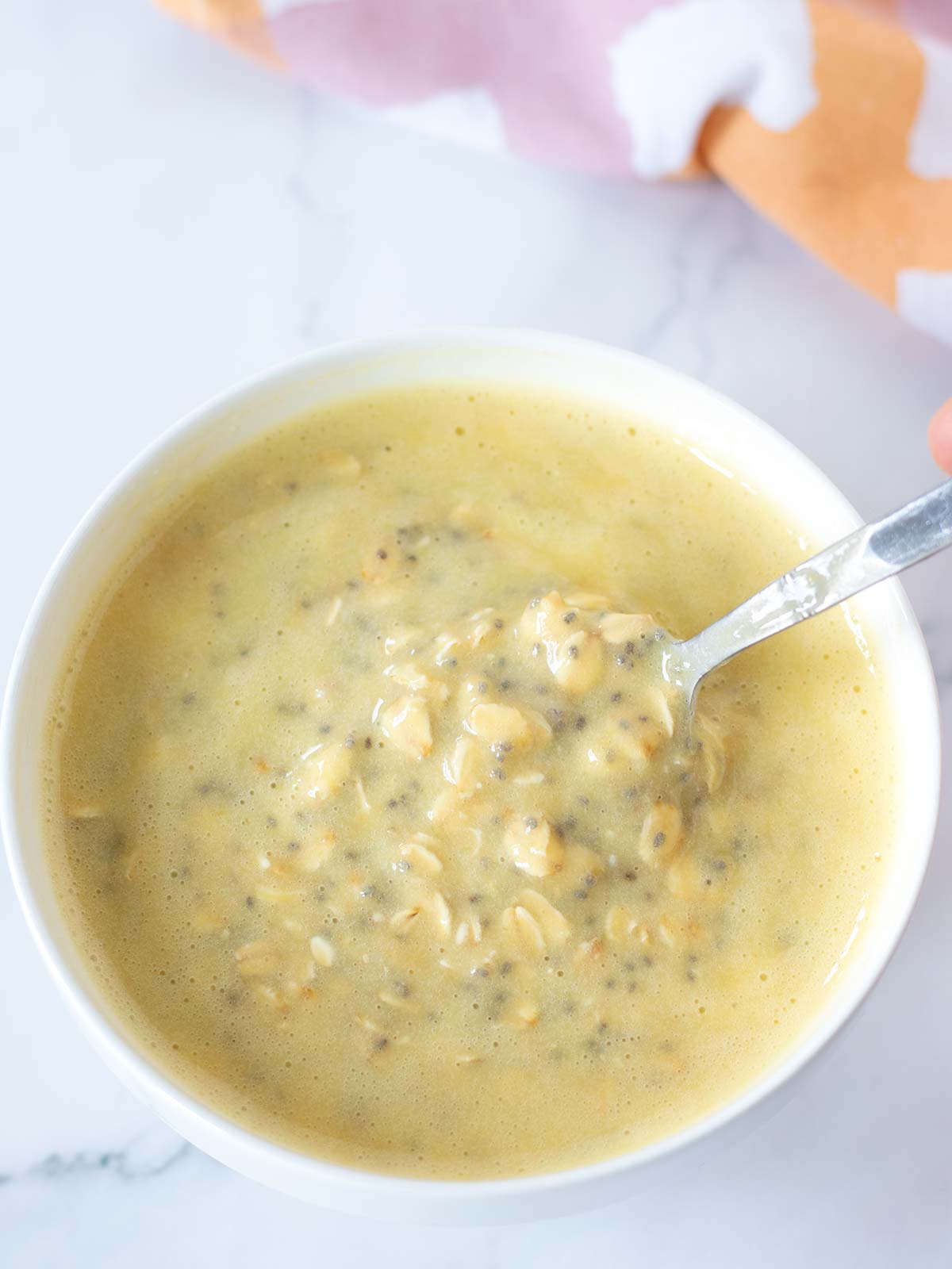 Creamy vegan overnight oats with mango and chia seeds in a bowl for breakfast.