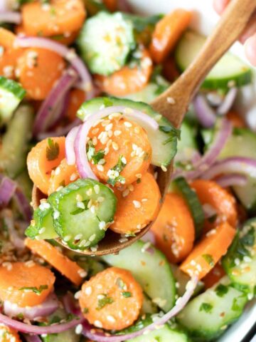 Simple cucumber carrot salad with sesame apple cider vinegar and olive oil dressing.