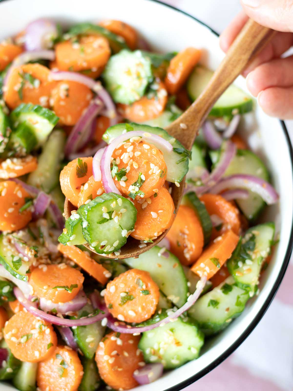 Simple cucumber carrot salad with sesame apple cider vinegar and olive oil dressing.