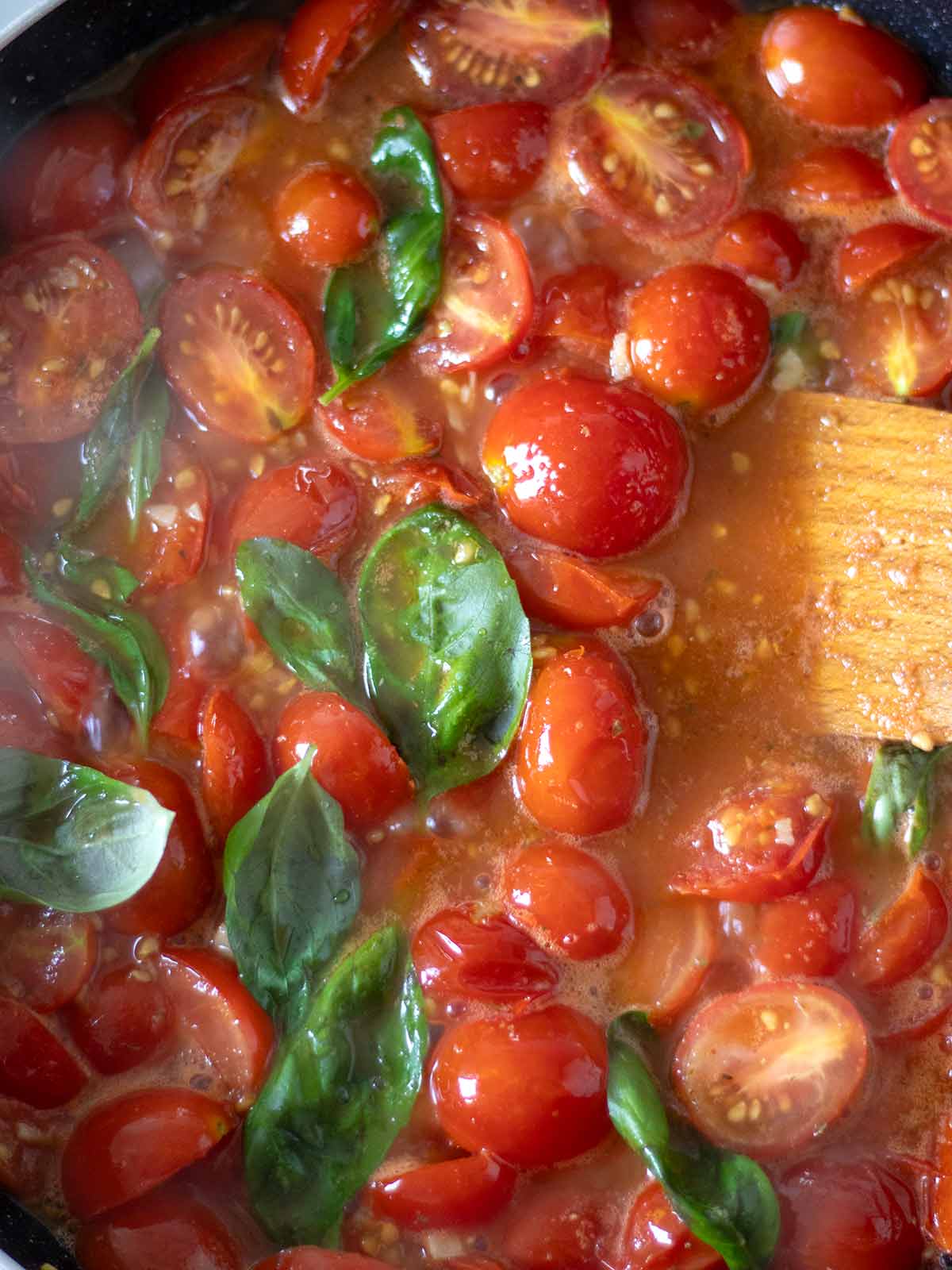 Cooking fresh grape tomato sauce for pasta.