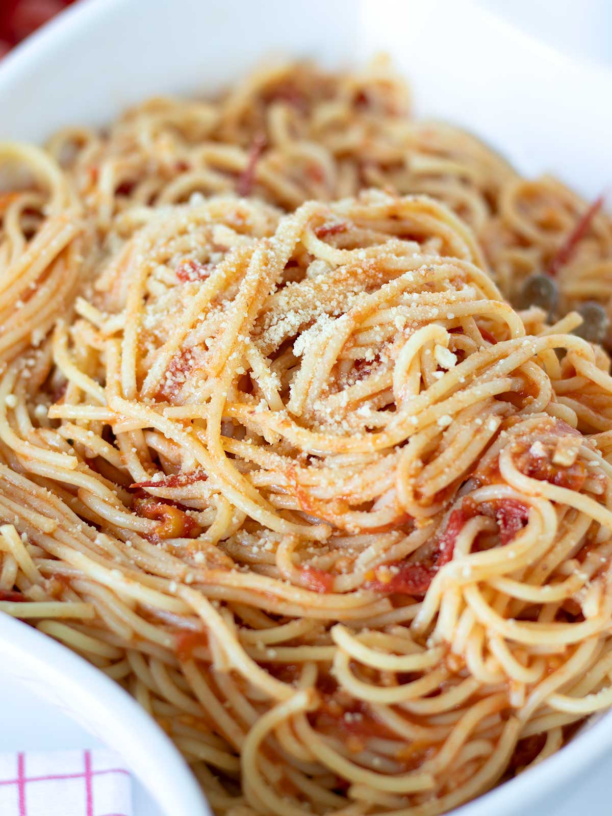 Grape tomato pasta sauce served with spaghetti in a dish.